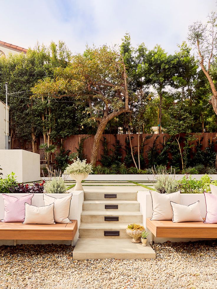 an outdoor seating area with wooden benches and plants