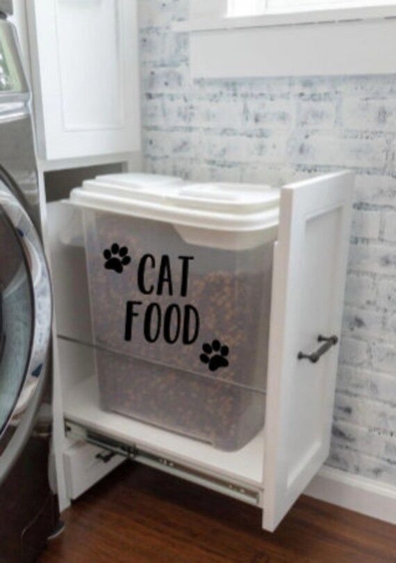 a cat food dispenser sitting next to a washer and dryer