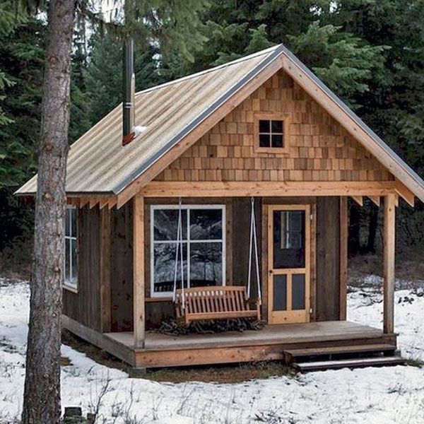 a small wooden cabin with a porch and swing