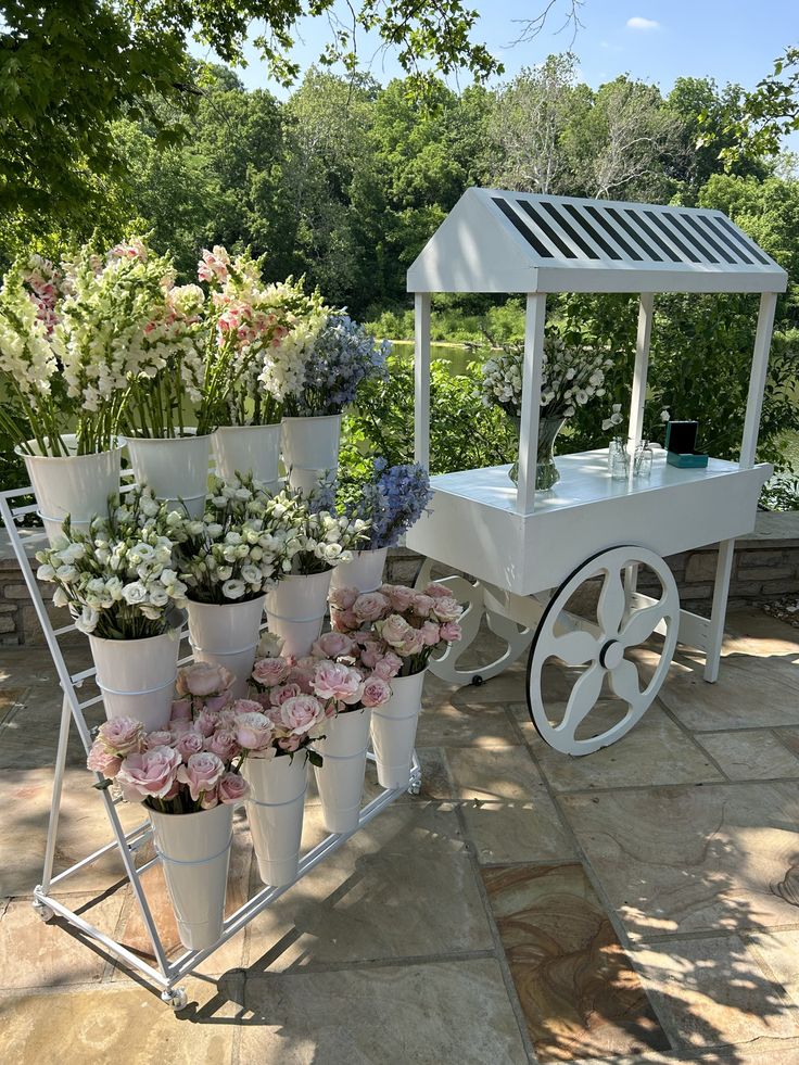 a cart filled with lots of flowers sitting on top of a stone floor