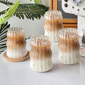 four white and brown vases sitting on top of a table next to a toaster