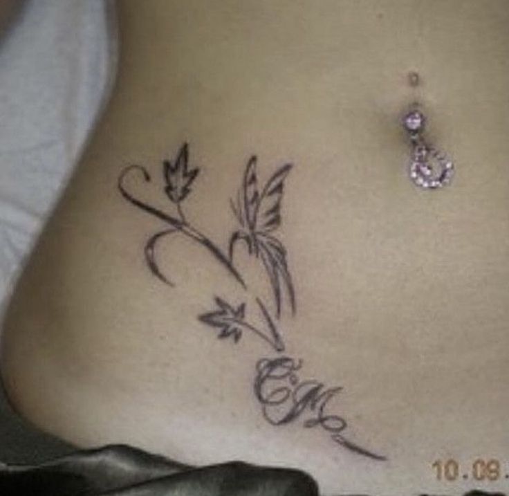 a woman's stomach with a tattoo on it that reads love and has flowers growing out of it