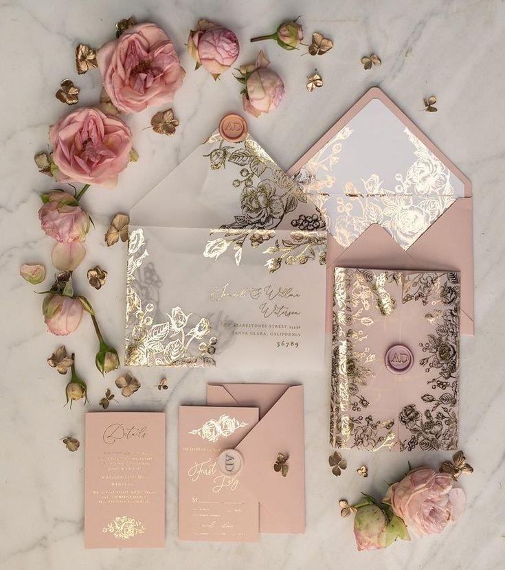 the wedding stationery is laid out on top of the marble table with pink flowers