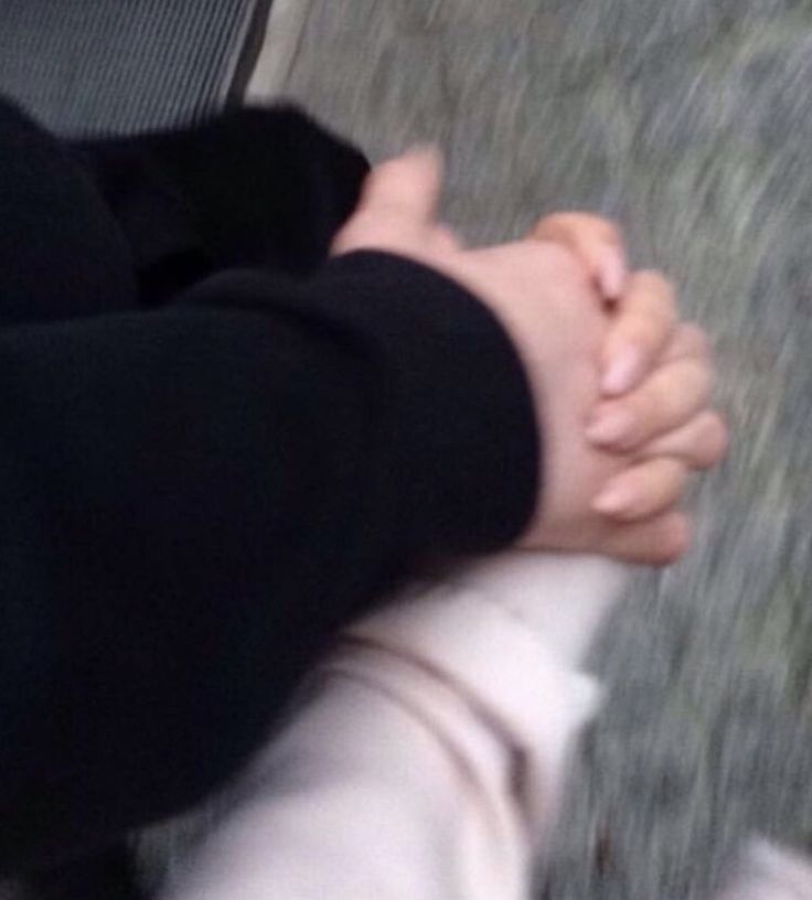 two people holding hands while walking down the street with their feet in the air and one person's hand on the ground