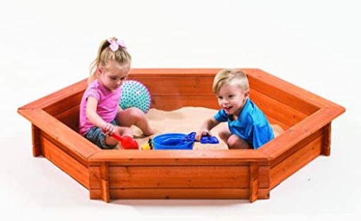 two young children playing in a sandbox