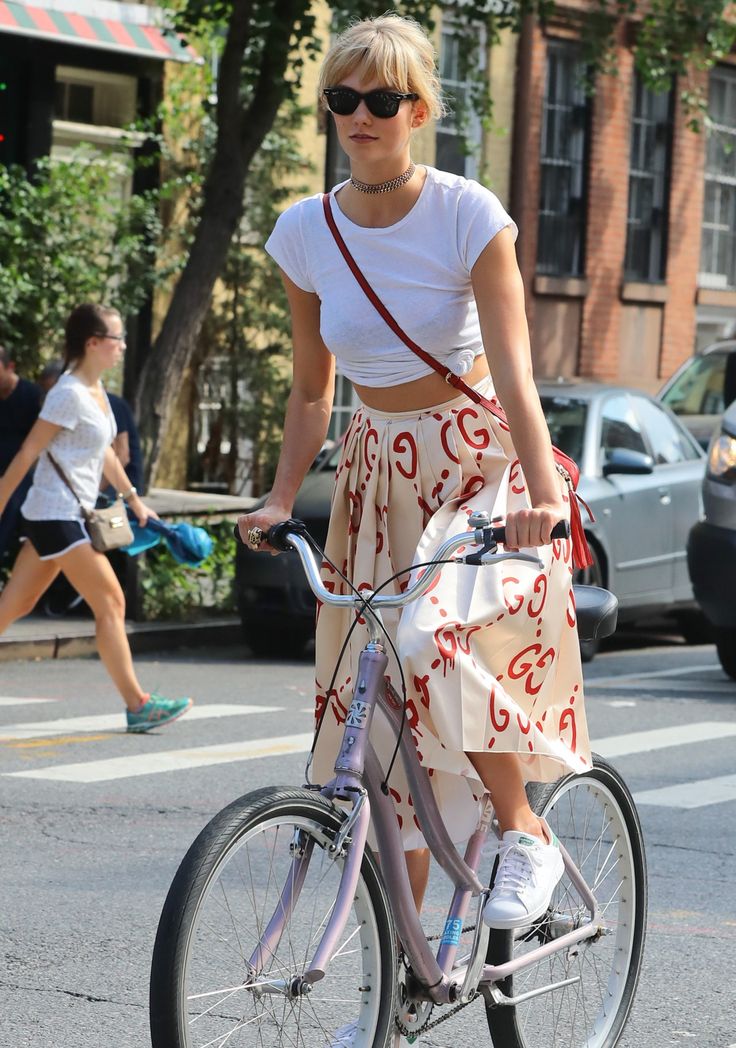 a woman is riding her bike down the street