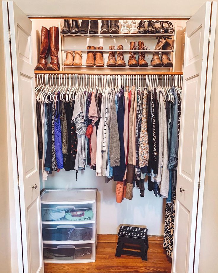 an open closet with clothes and shoes hanging