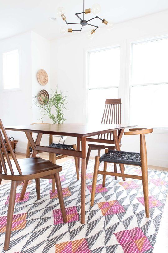 a dining room table with four chairs and a rug