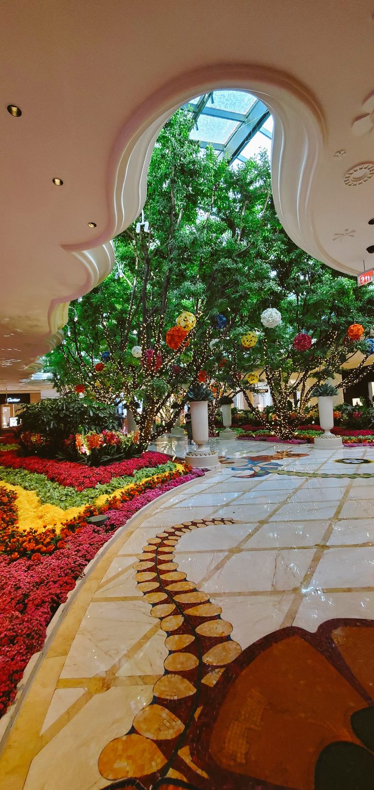 the inside of a building with flowers and trees