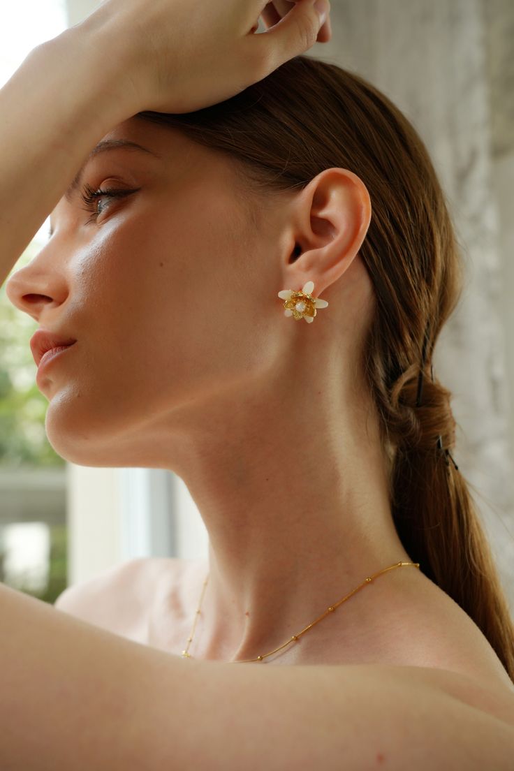 Evoke the essence of spring with the Magnolia Floral Stud Earrings, blooming with timeless elegance. Delicate magnolia blossoms crafted in intricate detail cradle lustrous pearls, creating a captivating floral motif. These earrings are the perfect accessory to elevate any outfit, whether it's a romantic date night or a casual brunch with friends. Pair them with a floral sundress and sandals for a fresh and feminine look, or with a tailored blazer and trousers for a sophisticated touch to your wo Feminine Blossom Jewelry For Spring, Elegant Spring Petal Shaped Flower Earrings, Elegant Flower Jewelry For Spring, Elegant Spring Flower Jewelry, Feminine Blossom Flower Jewelry, Spring Wedding Jewelry With Petal Design, Feminine Petal-shaped Jewelry For Spring, Feminine Earrings With Flower Decoration, Feminine Gold Jewelry With 3d Flowers