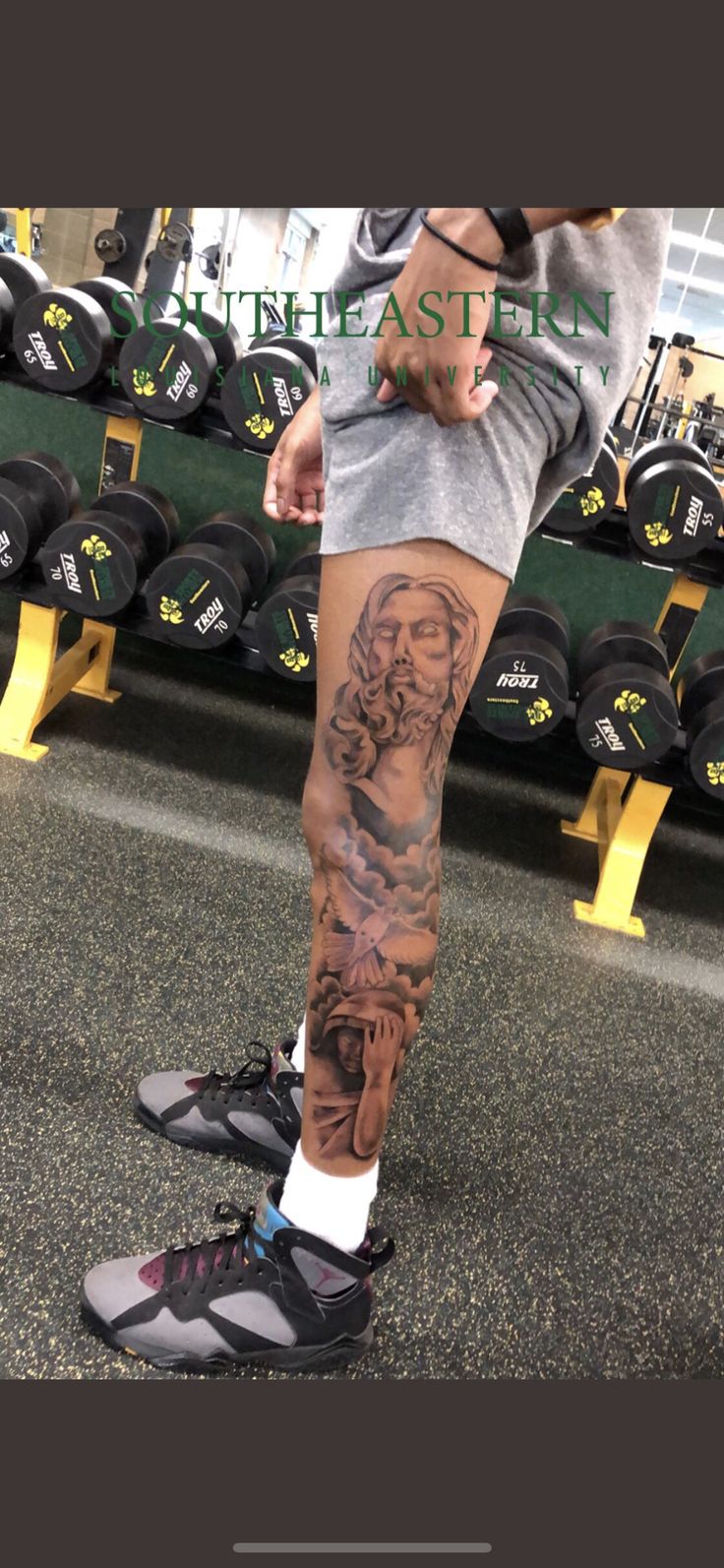 a man's leg with tattoos and sneakers