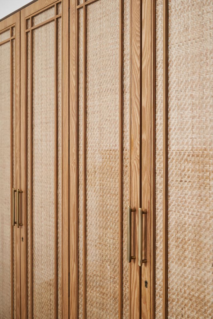 a wooden room divider with woven coverings on it's sides and doors