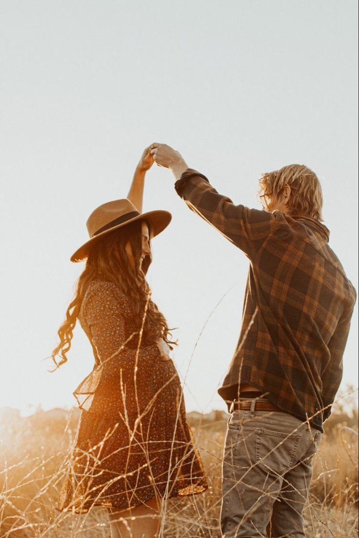 a man and woman standing in tall grass