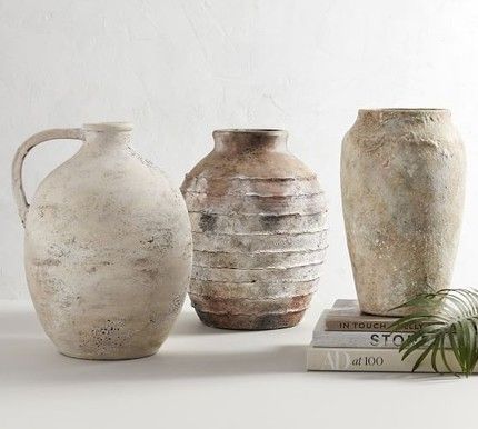 three vases sitting next to each other on top of a table