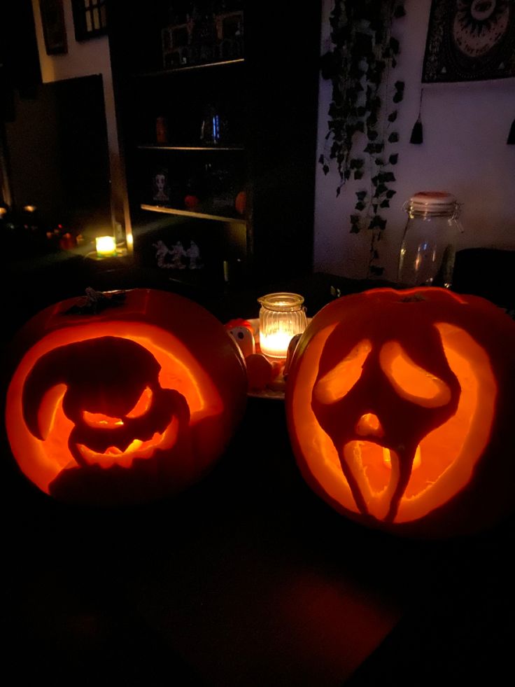 two carved pumpkins sitting on top of a table