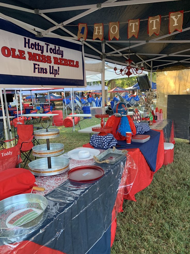 an outdoor event with red, white and blue tables covered in plastic bags under a canopy