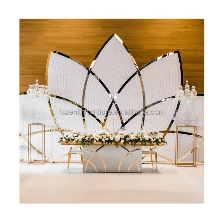 a large white flower arrangement in front of an art deco display at a wedding reception