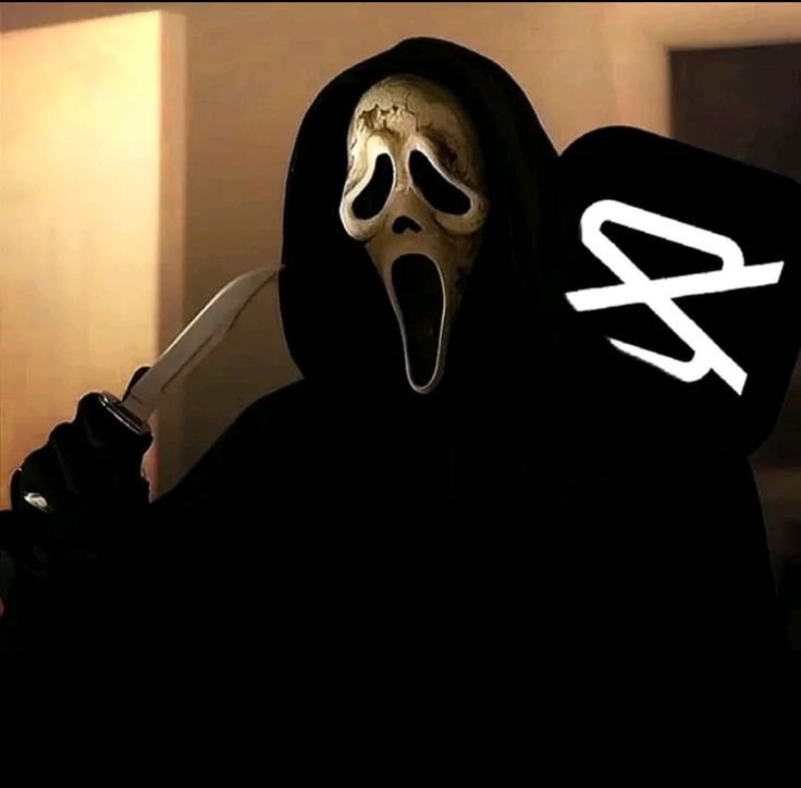 a person wearing a mask and holding a knife with the word scream written on it