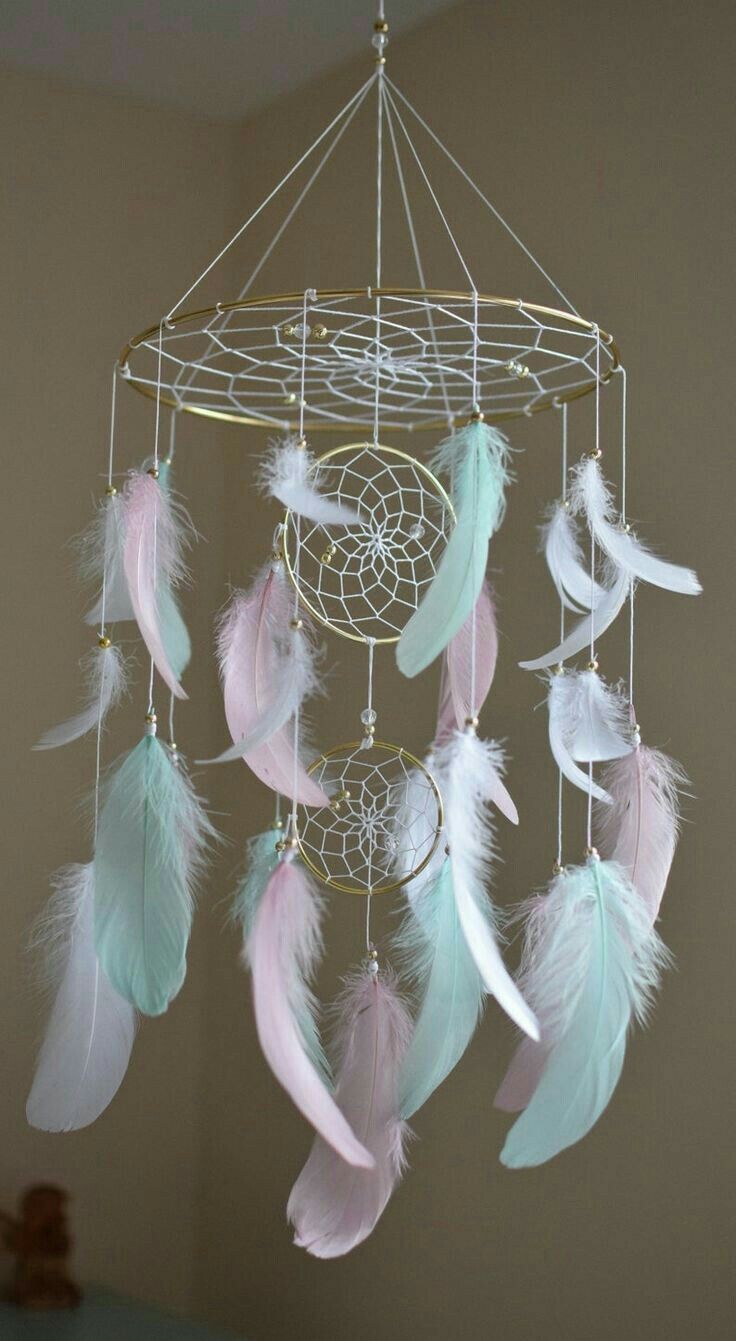 a white and pink dream catcher hanging from the ceiling