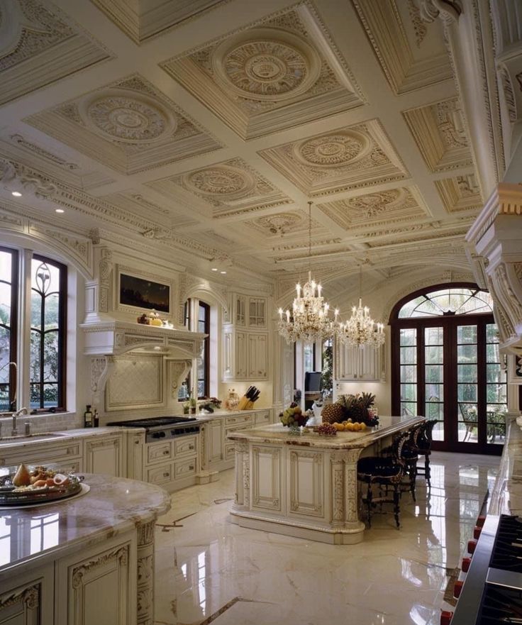 an ornate kitchen with white cabinets and marble counter tops, chandelier, stove top oven, sink, and dining room table