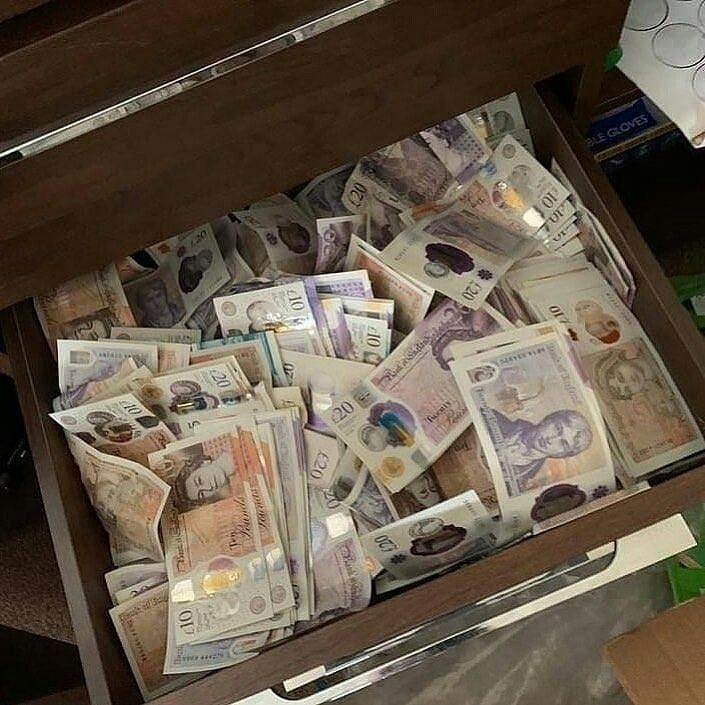 a drawer filled with lots of money sitting on top of a table