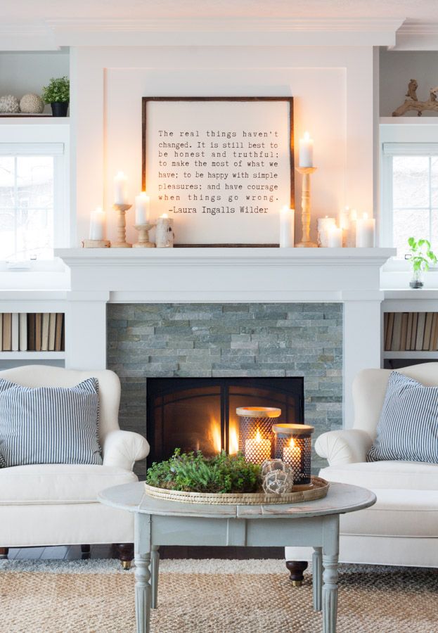 a living room filled with furniture and a fire place in front of a brick fireplace