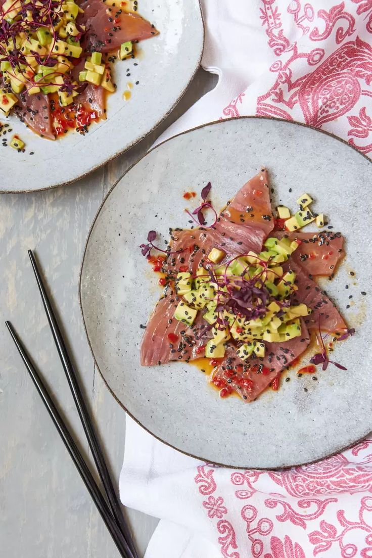 two plates with food on them and chopsticks next to each other in front of the plate