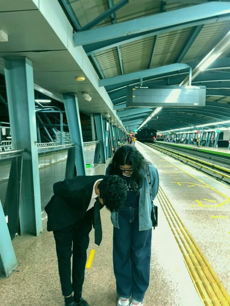 two people walking down a train station platform