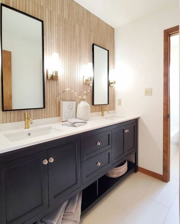 a bathroom with double sinks and two mirrors on the wall next to eachother