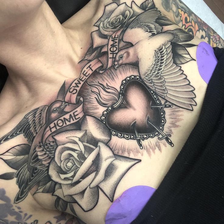 a woman's chest with tattoos and roses on her left side, in the shape of a heart