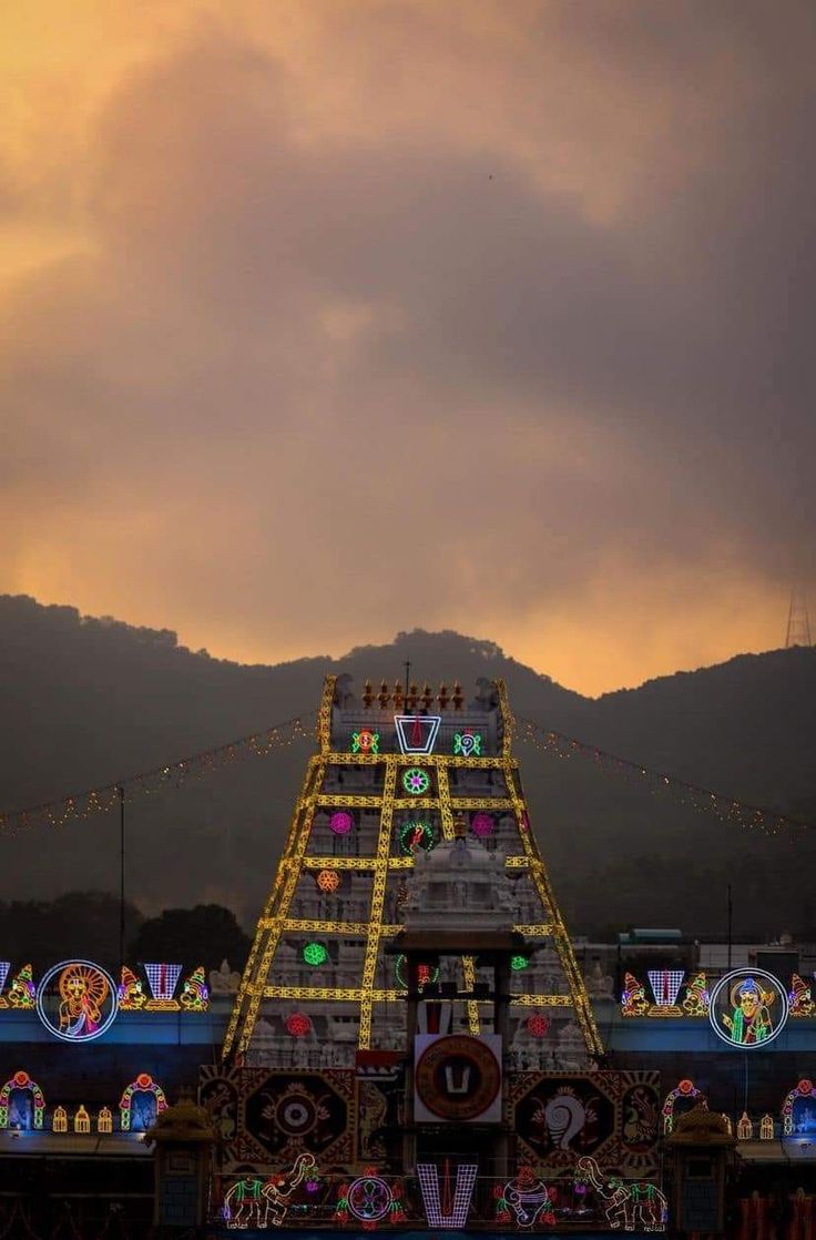 an elaborately decorated float in the middle of a body of water with mountains in the background