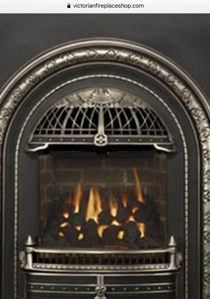 an ornate fireplace with fire burning in it