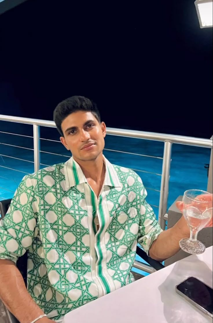 a man sitting at a table with a glass of wine in front of him on the deck of a cruise ship