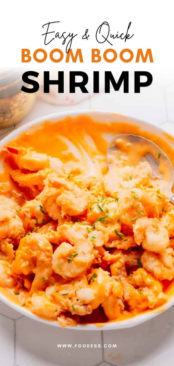 a white bowl filled with shrimp and sauce on top of a table next to a spoon