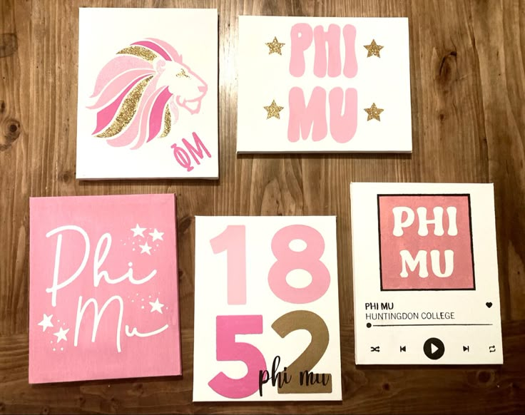 some pink and white greeting cards on a wooden table with gold foil stars in the background