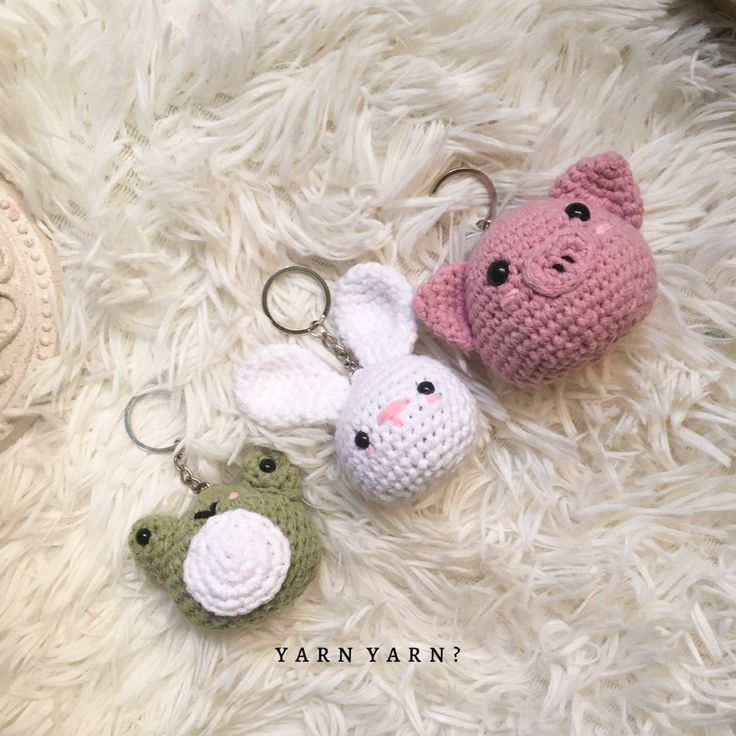 two crocheted keychains are laying on a furry surface