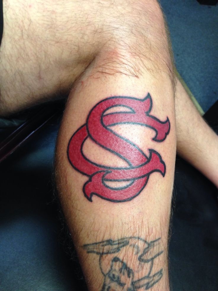 a close up of a person with a tattoo on his leg and the letter s