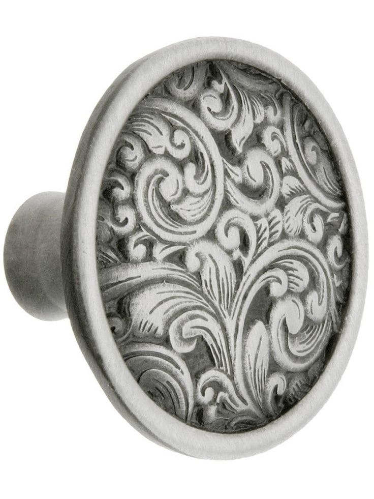 an ornate metal cabinet knob on a white background