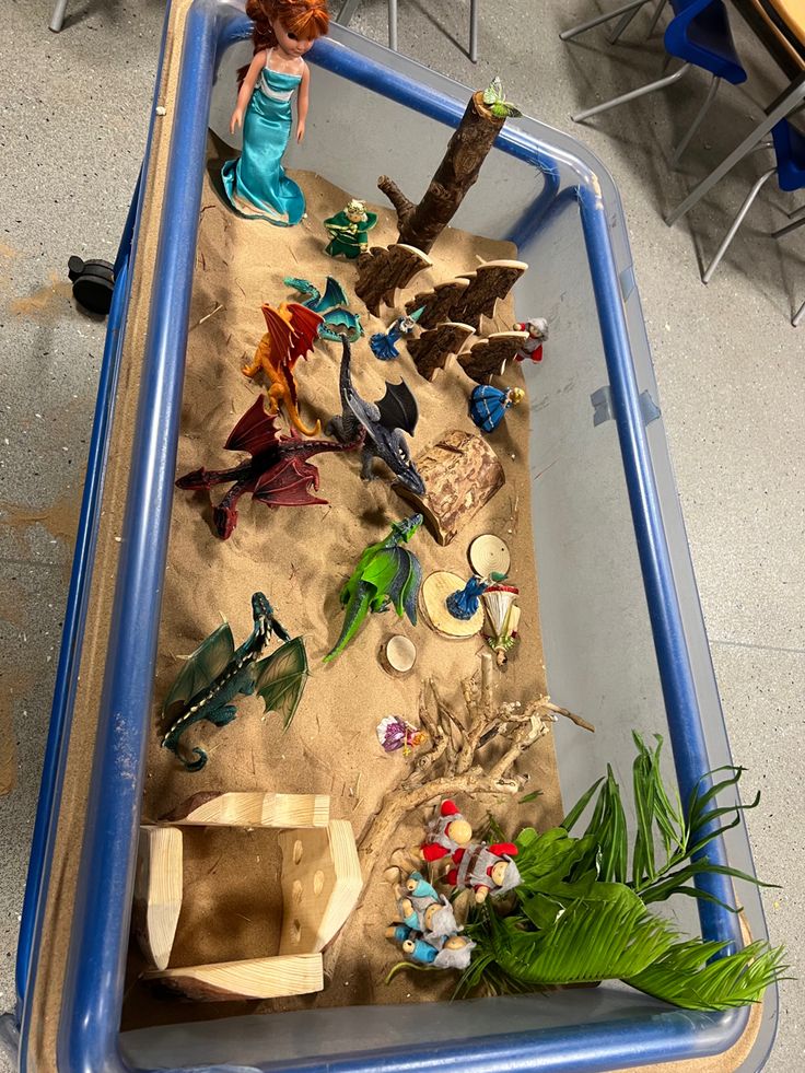 there is a sand tray with toys in it