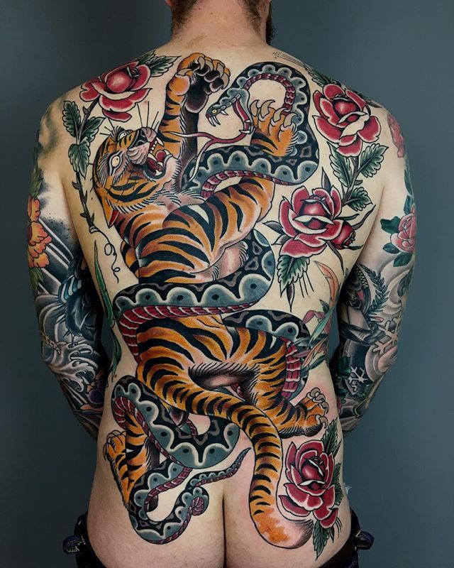 the back of a man with tattoos on his body