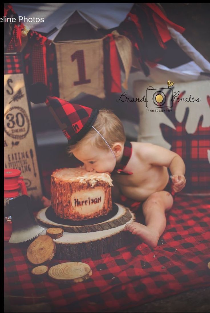 a baby boy sitting in front of a birthday cake