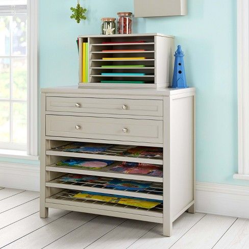 a white dresser with magazines on it in a blue room