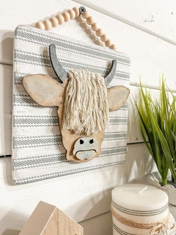 a cow head hanging on the side of a wall