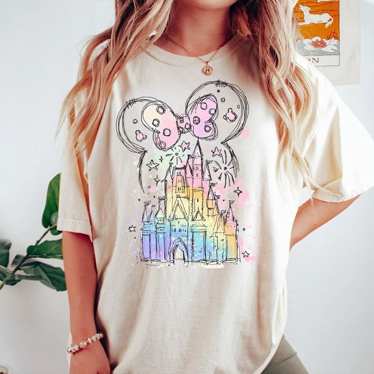 a woman with blonde hair wearing a white tshirt that has a castle on it