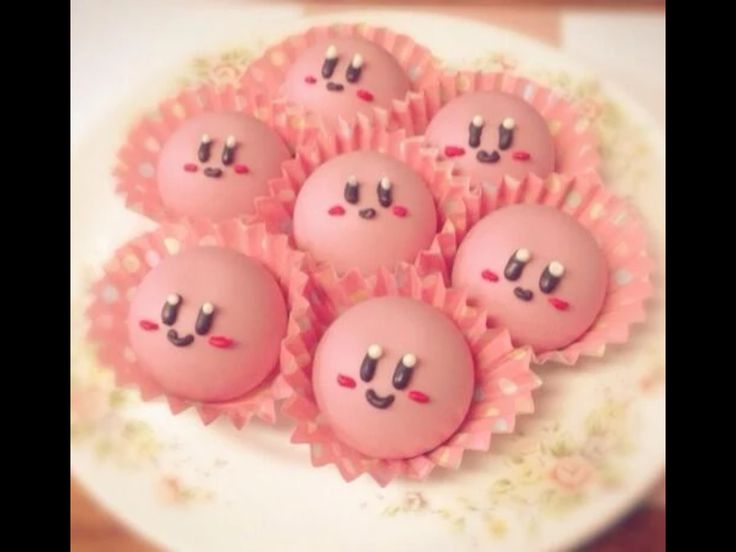 there are some pink cake balls with faces on them