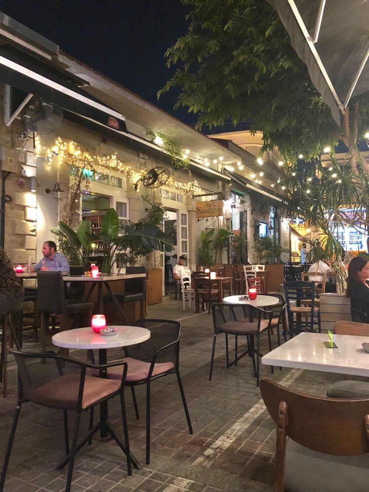 people sitting at tables in an outdoor restaurant