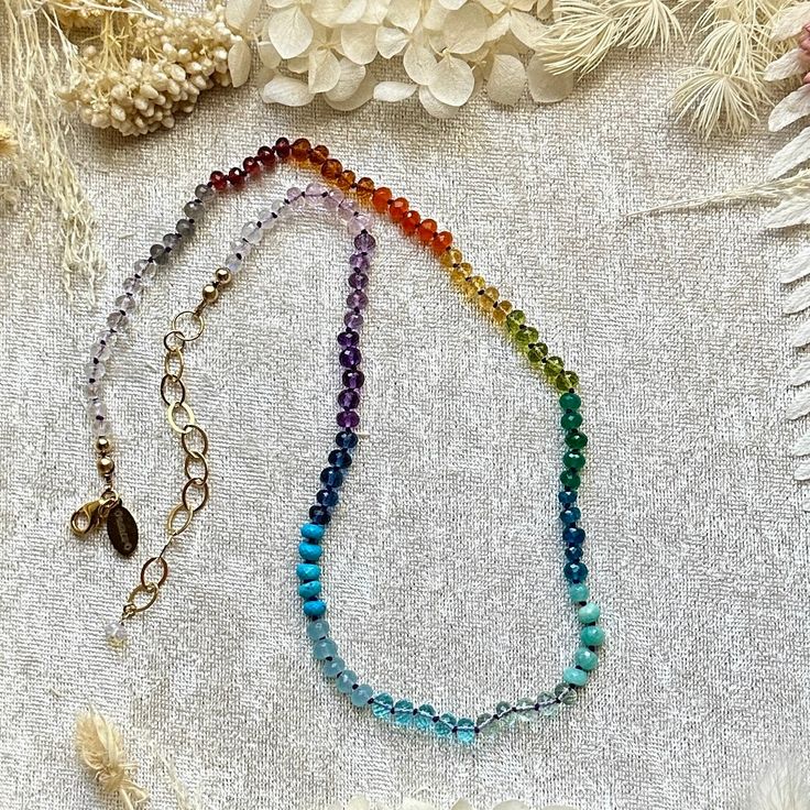 A rainbow mix of natural AAA gemstones and AAA hydro quartz.  Length: 17.5" inch with 2" inch extender.  Findings are 14kt gold-filled. The brand tag is brass.  Gemstone beads are about 4-5mm.  The silk-knotting (aka hand-knotting) technique adds an elegant drape to the necklace, with each bead held securely in place with silk knots between them. These make wonderful gifts with an heirloom feel and they are perfect for layering with chains and other necklaces too! These luxurious, lovingly craft Rainbow Crystal Necklace With Natural Stones, Knotting Technique, Knotted Necklace, Rainbow Gemstones, Elegant Drapes, Knot Necklace, Brand Tags, A Rainbow, 14kt Gold