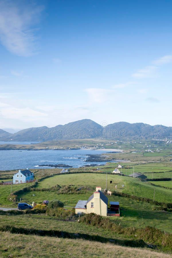 a small house in the middle of a field with mountains in the background royalty images