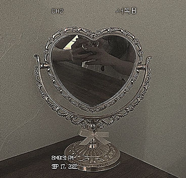 a heart shaped mirror sitting on top of a wooden table