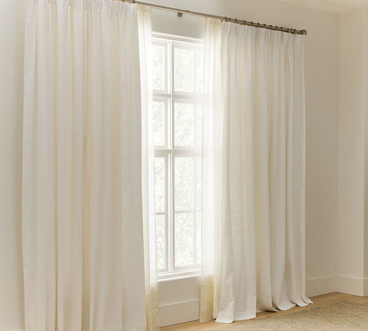 a white curtain hanging in front of a window